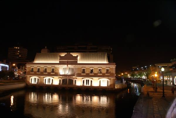 Illuminated building by the canal at night, lights reflecting on dark water