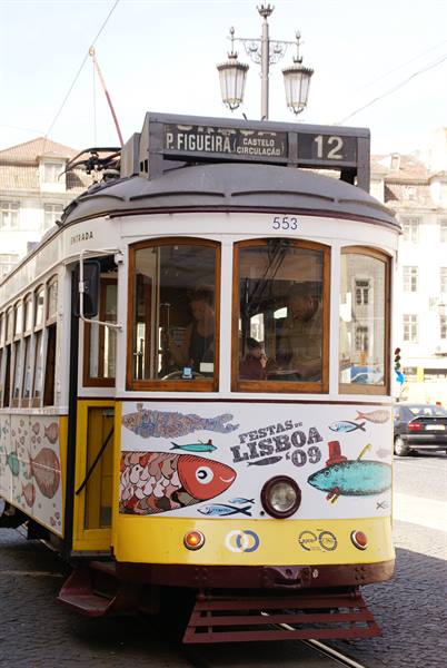 Yellow and white tram number 12 on tracks, Lisbon