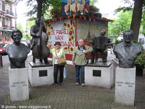 Couple among bronze musician statues and busts at Johnny Jordaanplein, Amsterdam
