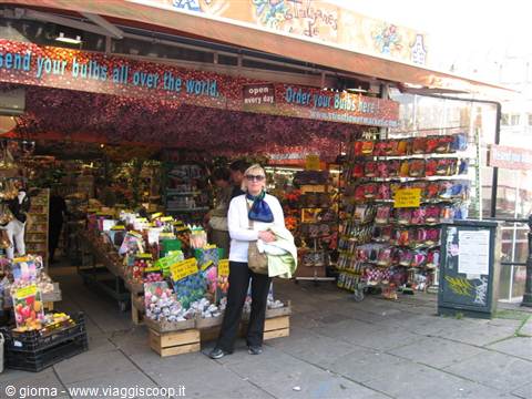 Tourist in front of Amsterdam's bulb market, stalls full of seeds and colorful signs