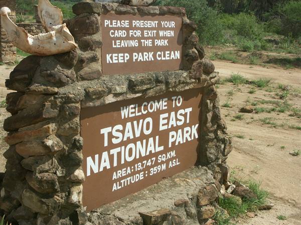 Stone and wooden entrance sign at Tsavo East National Park