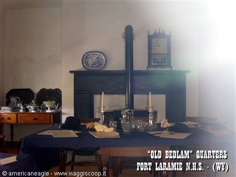 Historic dining room with set table, black fireplace and clock, Fort Laramie