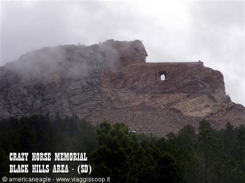 Crazy Horse Memorial shrouded in fog above pine forests in the Black Hills