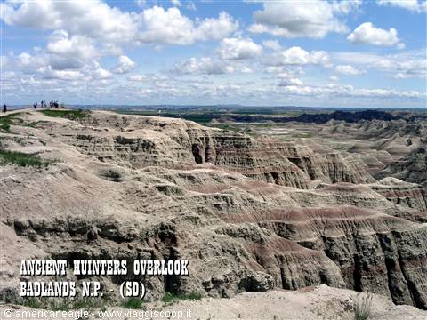 Tourists at Ancient Hunters Overlook, Badlands, eroded rock formations under clouds