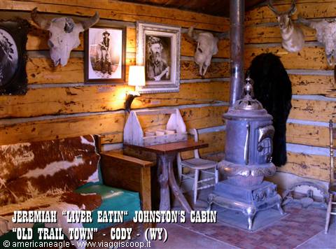 Log cabin with antique cast-iron stove, cow skulls and old portraits, Old Trail Town, Cody