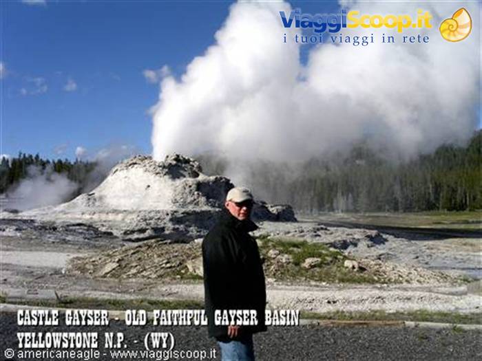Man in front of erupting Castle Geyser, Yellowstone