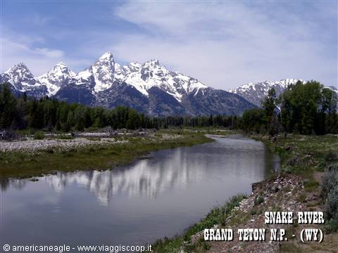 Snake River reflects the snow-capped Grand Teton peaks among green trees