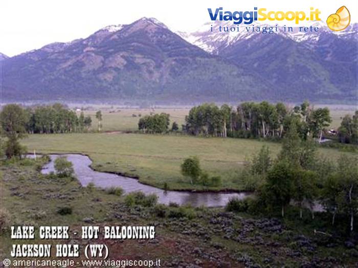 Lake Creek river winding through green meadows, snowy mountains, Jackson Hole