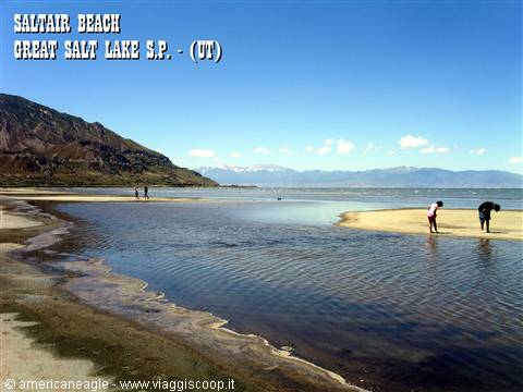 Salty beach at Saltair on Great Salt Lake, visitors on shore beneath mountains