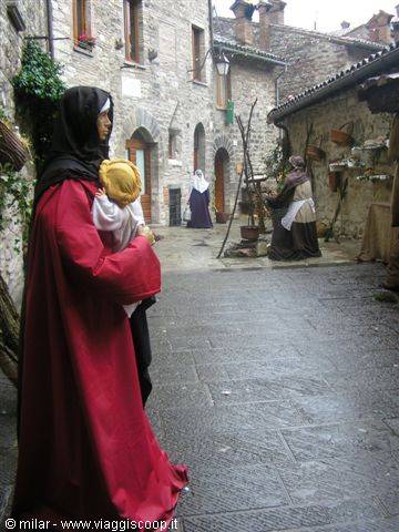 Nativity figures in stone-paved alley among medieval stone houses