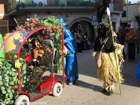 Carnival parade: decorated float with plants and a straw-costumed masked figure