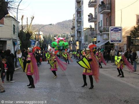Carnival parade down the street: performers with yellow wings and pink capes