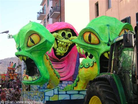 Carnival float with green monsters and pink skeleton pulled by tractor
