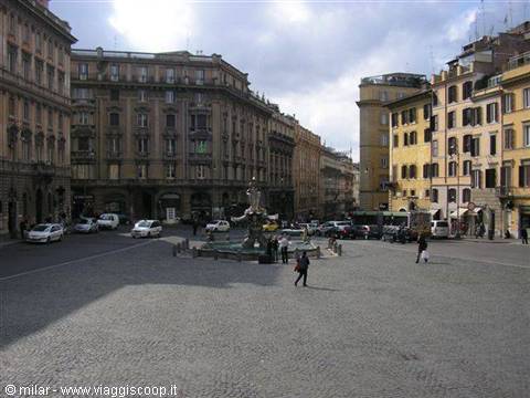 Baroque fountain in the middle of a cobblestone square with historic buildings