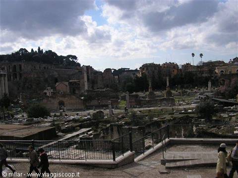 Tourists by the Roman Forum ruins among columns and clouds