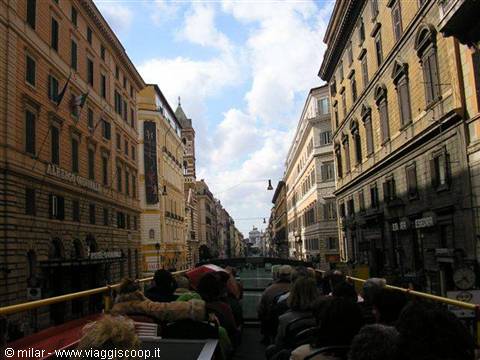 Tourists on an open-top bus driving through historic Via Nazionale, Rome