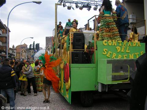 Green carnival float Contrada del Serpente with dancers in feathered costumes