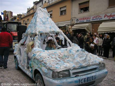 Car decorated as an iceberg at carnival, crowd along the street