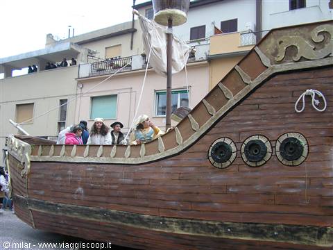 Carnival float shaped like a wooden galleon with people on board