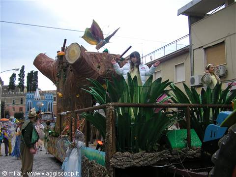 Carnival float with wooden trunk and green leaves in the street