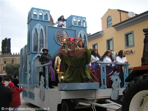 Blue carnival float with costumed characters parading through town square