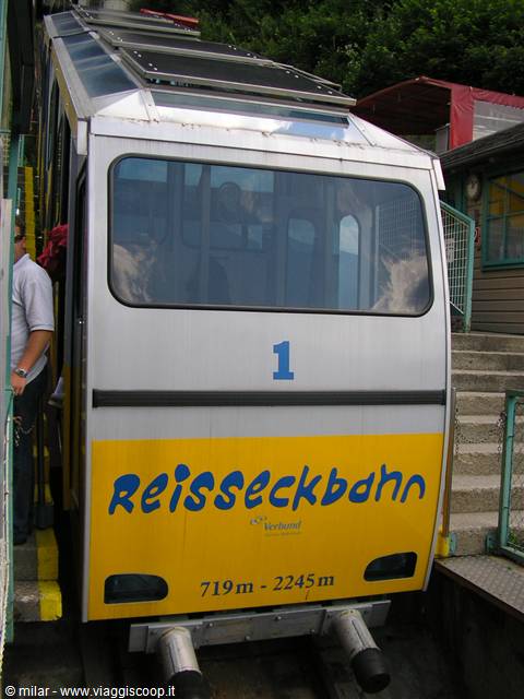 Silver and yellow Reisseckbahn funicular at the station, man boarding