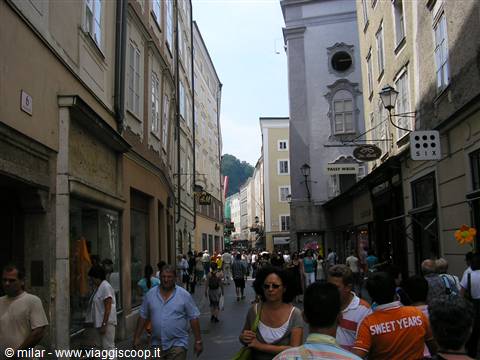 Crowd of tourists on busy pedestrian street with historic buildings in Salzburg