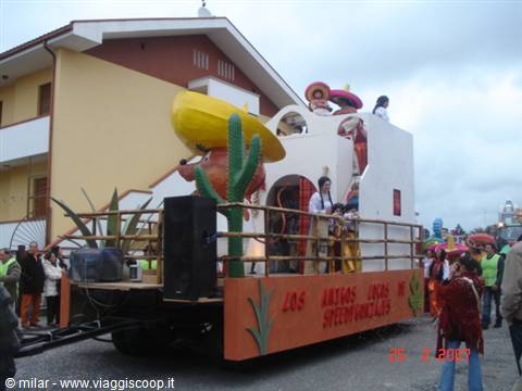 Mexican-themed carnival float with cactus and sombrero, spectators along the street