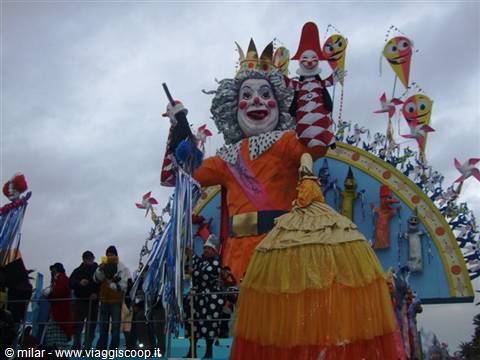 Viareggio Carnival float with giant jester figure in orange costume under gray sky