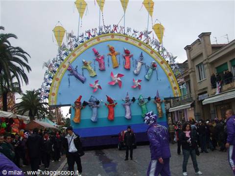 Colorful carnival float with papier-mâché figures parading among the crowd