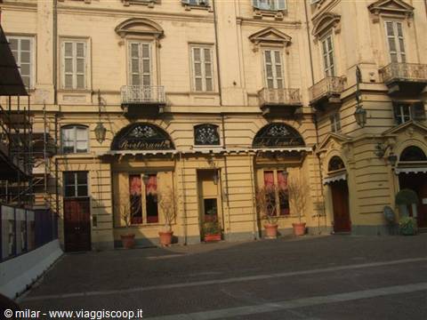 Ochre-yellow historic building facade with a restaurant on the ground floor