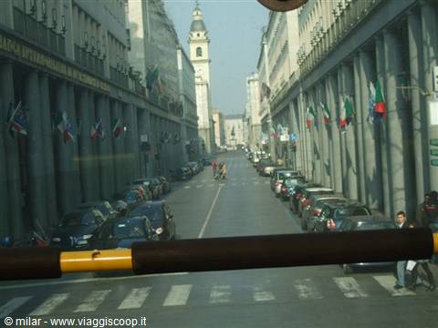 Street with Italian flags in Trieste, church bell tower, photographed through the bus window