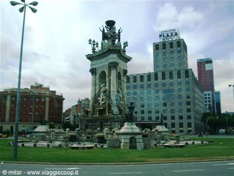Stone monumental fountain at Plaça d'Espanya, Barcelona, with skyscrapers behind