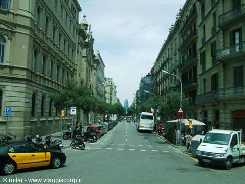 Street with black and yellow taxi, buildings and Torre Agbar in the distance, Barcelona