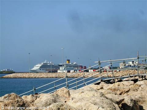 Cruise ship docked at the harbor, rock breakwater and metal gangway