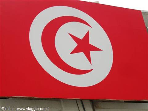 Tunisian red flag with white star and crescent on a building