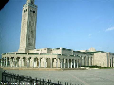 Minaret and arcades of the Hassan II Mosque under Casablanca's clear blue sky