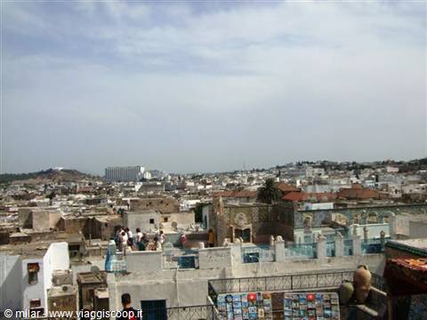 Rooftops of Tangier medina, people on terraces under a cloudy sky