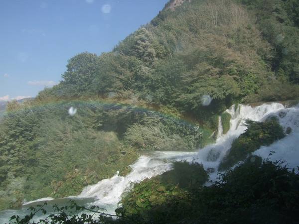 Marmore Falls surrounded by greenery, rainbow over the white water