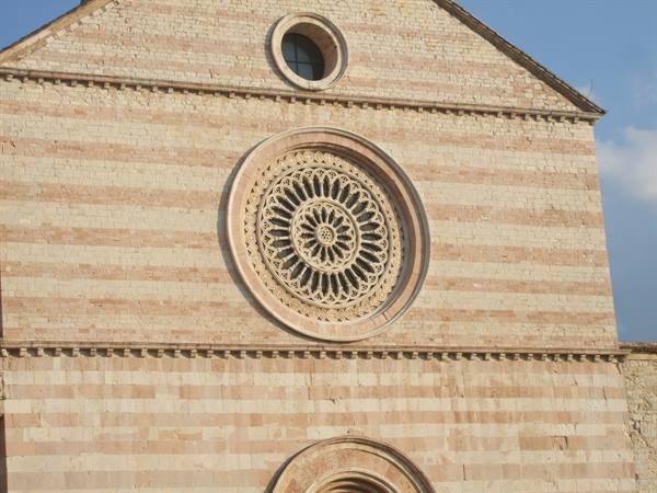 Gothic rose window on the striped stone facade of Santa Chiara, Assisi
