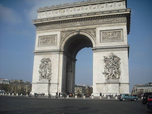 Arc de Triomphe in Paris, stone sculptures, tourists and cars on the square