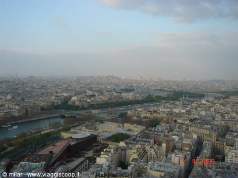 Paris from the Eiffel Tower: the Seine, bridges and grey rooftops under clouds