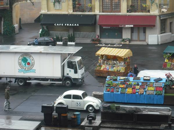 Delivery truck and Beetle car number 53 beside fruit stalls and Café Fracas