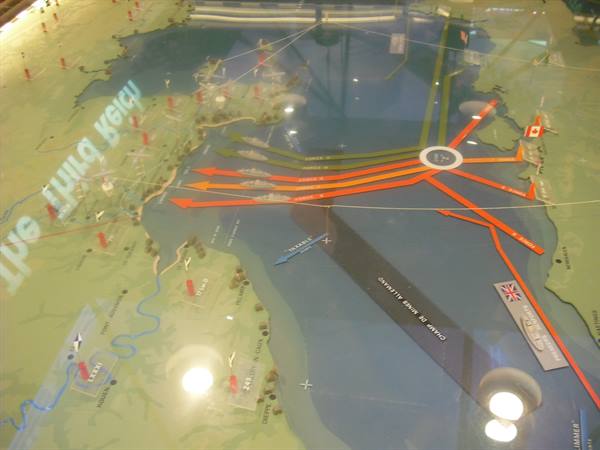 Museum diorama map with orange arrows showing Allied invasion routes