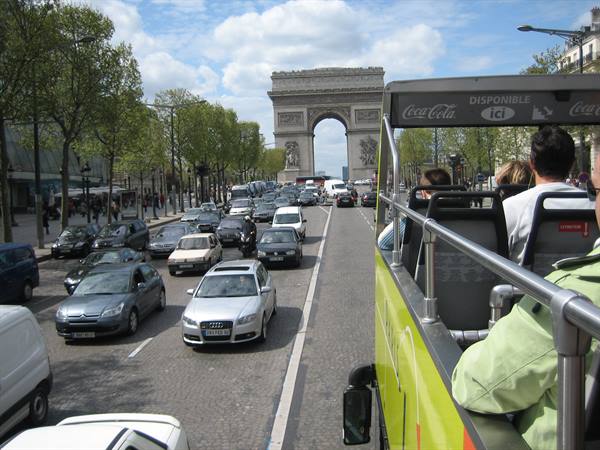 Tourists on open-top bus heading to the Arc de Triomphe, heavy traffic
