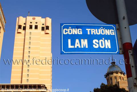 Blue street sign Còng Truòng Lam Sơn in front of a beige high-rise tower