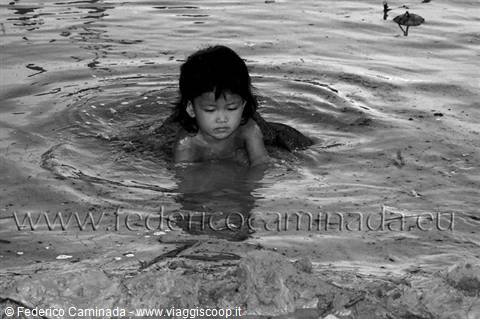 Child wading in dark water, black and white