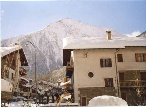 Snow-covered houses in Courmayeur beneath the white mountain, winter light