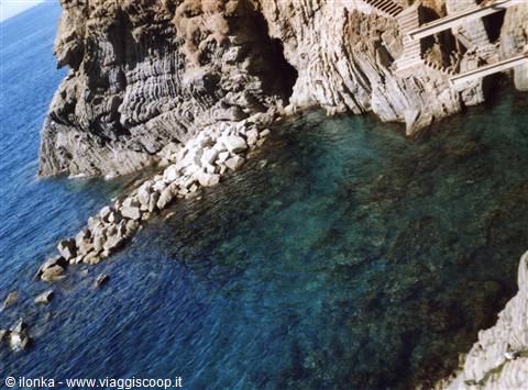 Turquoise water between rocks and stairs carved into the cliff, Cinque Terre