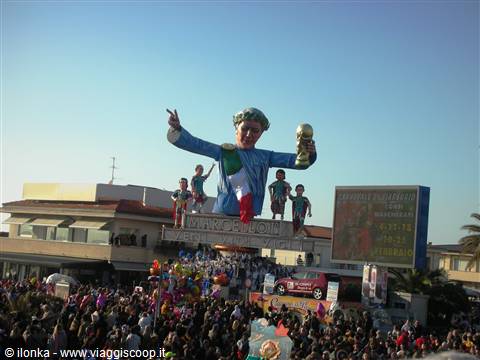 Viareggio Carnival: papier-mâché float with policeman holding trophy, crowd below